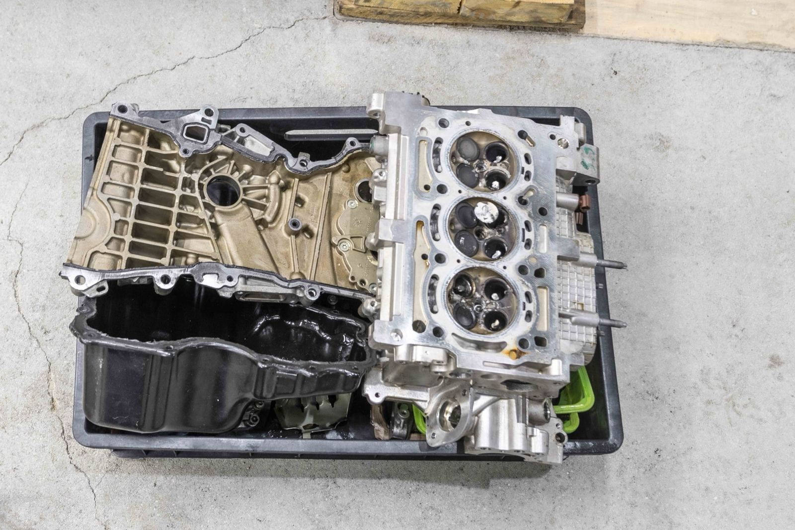 Zerlegter Motor mit Zylinderkopf und Ölwanne in einer Transportwanne