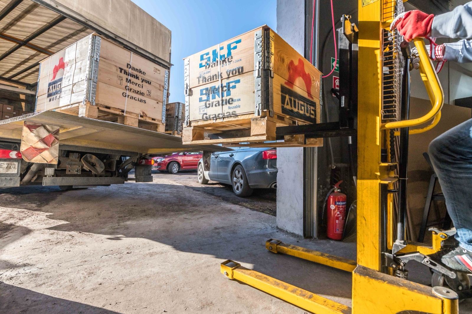 Verpackte Ersatzteile werden mit dem Hubwagen auf den LKW verladen