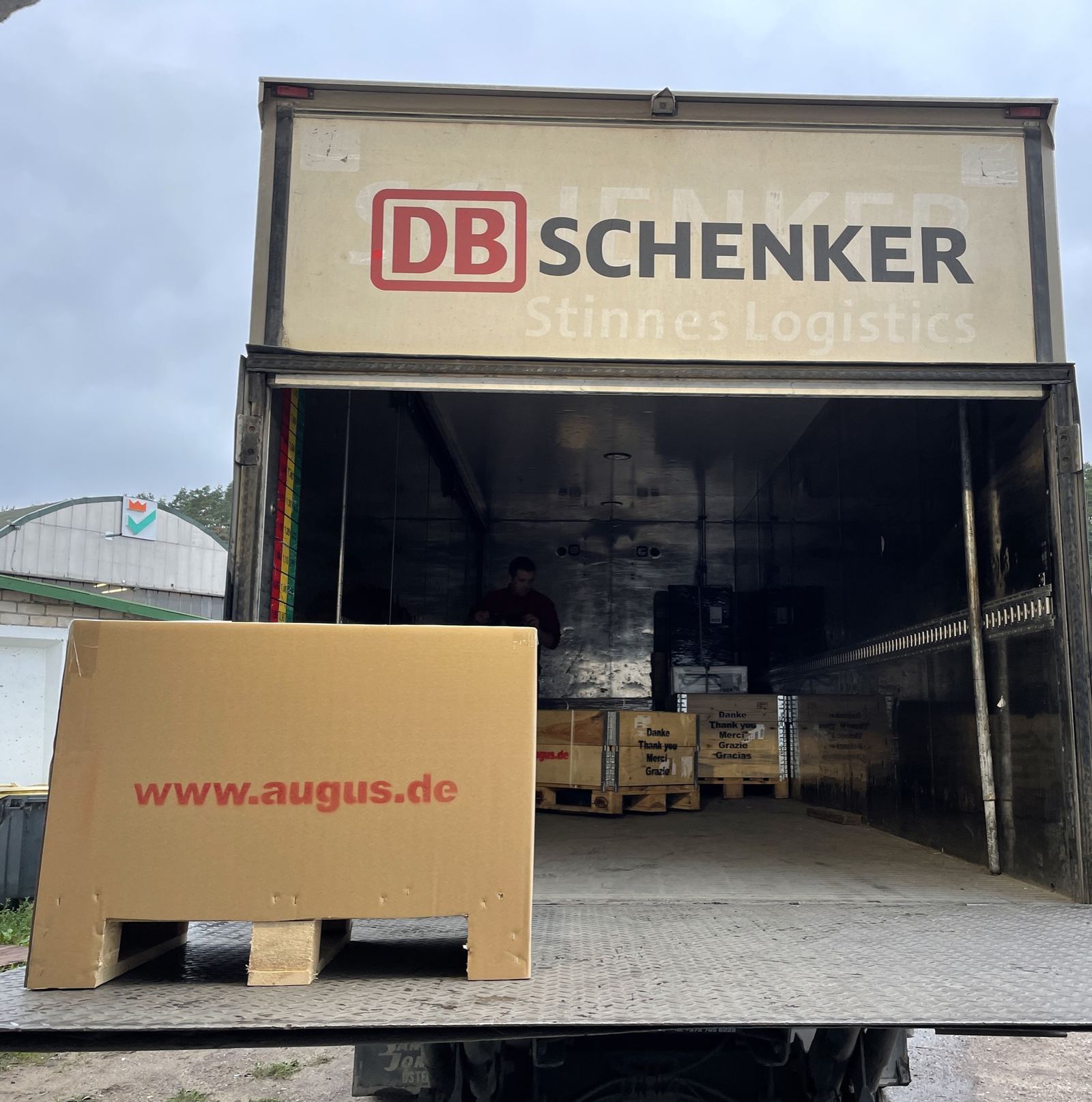 Versandfertiger Motor vor einem geöffneten LKW von DB Schenker